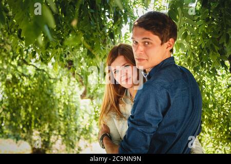 Felice elegante coppia amorevole di hipster abbracciare in un parco Foto Stock