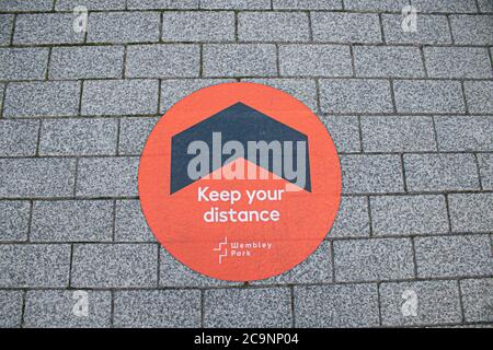 WEMBLEY LONDON, UK - 1 agosto 2020 Decal di allontanamento sociale sul pavimento sulla Olympic Way. La finale di quest'anno, che si tiene tradizionalmente a maggio, ha dovuto essere riprogrammata e si terrà a porte chiuse, senza alcun sostenitore autorizzato a fermare la diffusione del coronavirus Covid-19 e sarà la prima 'Fanless fa Cup Final'. Credit: amer Ghazzal/Alamy Live News Foto Stock