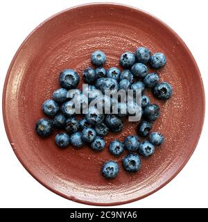 Bacche nere fresche o mirtilli in una piastra di ceramica di argilla marrone fotografata dall'alto. Primo piano di fragole fresche e salutari. Foto Stock