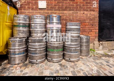 Pile di barili vuoti di birra inossidabile con bidone dei rifiuti sul retro del pub a Old Leigh, Leigh on Sea, Essex, UK, nel mese di luglio durante COVID-19. Contenitore rifiuti Foto Stock