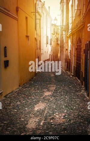 Sole che splende su un vicolo stretto nella città vecchia di Alghero. Sardegna, Italia Foto Stock