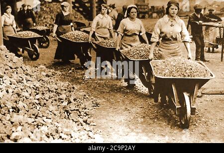 WWI - le donne britanniche che lavorano come operai di cantiere che sfila le barriole delle macerie. Per aiutare lo sforzo bellico, migliaia di donne sono state reclutate in posti di lavoro liberati da uomini che erano andati a combattere in guerra. Foto Stock