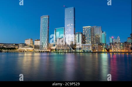 Il quartiere finanziario della città di Londra Canary Wharf rifletteva Il Tamigi all'ora blu in Inghilterra Foto Stock