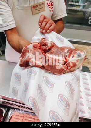 Budva, Montenegro - 01 agosto 2020: Il macellaio in negozio mostra la carne. Foto Stock