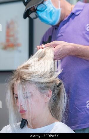 Una ragazza ha i suoi capelli tagliati durante il blocco a causa di Coronavirus Foto Stock