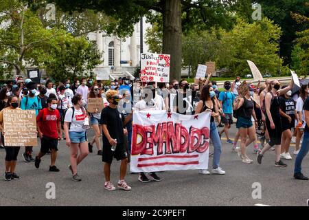 Washington, DC, Stati Uniti. 1 agosto 2020. Nella foto: Manifestanti che portano un banner e un cartello con la richiesta di giustizia per gli uomini neri uccisi dalla polizia metropolitana (polizia DC) durante la marcia Demand DC, ospitata dal collettivo Palm. I manifestanti chiedono quattro cambiamenti al governo cittadino: Scuole libere dalla polizia, fine dell’immunità qualificata per gli agenti di polizia, un nuovo dipartimento di sicurezza pubblica e designazione del giorno delle elezioni come vacanza. Credit: Allison C Bailey/Alamy Credit: Alison Bailey/Alamy Live News Foto Stock