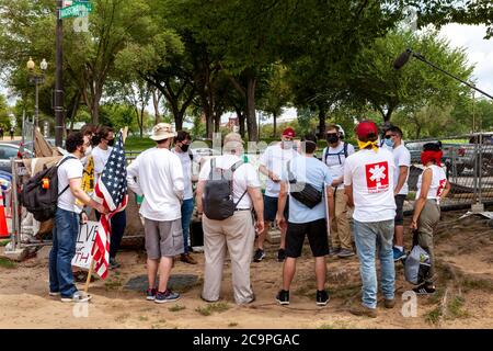 Washington, DC, Stati Uniti. 1 agosto 2020. Nella foto: Veterani militari statunitensi - membri di continuano a servire - discutono i loro piani di marcia al Museo Nazionale di Storia e Cultura Africana americana, prima dell'inizio del raduno Demand DC, sponsorizzato dal collettivo Palm. I manifestanti chiedono quattro cambiamenti al governo cittadino: Scuole libere dalla polizia, fine dell’immunità qualificata per gli agenti di polizia, un nuovo dipartimento di sicurezza pubblica e designazione del giorno delle elezioni come vacanza. Credit: Allison C Bailey/Alamy Credit: Alison Bailey/Alamy Live News Foto Stock