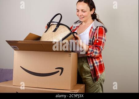 15 luglio 2020. Bologna, Italia. Disimballaggio del pacchetto Amazon. Una donna toglie il cappello e la borsa per la vacanza estiva. Concetto di mailing di successo, servizio per la casa e il business, acquisti online Foto Stock