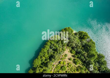 vista aerea dall'alto del lago di cava e dell'isola con la foresta verde in una giornata estiva soleggiata Foto Stock