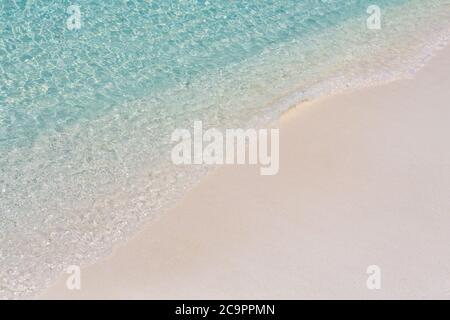 Onda del mare, acque poco profonde, oceano chiaro su sabbia bianca. Tranquille onde blu. Bellissima spiaggia di sabbia e dalle onde blu dell'oceano Foto Stock
