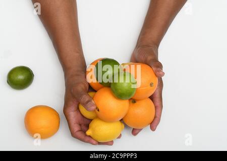 CITRUS PARTY: Una collezione di arance, lime e limoni sono disposti in un piano steso su uno sfondo bianco puro. Foto Stock