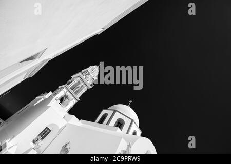 Immagine in bianco e nero della chiesa di Santorini Oia, Grecia. Foto monocromatica astratta, architettura bianca sotto il cielo scuro. Sfondo artistico Foto Stock