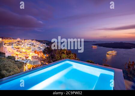 Incredibile paesaggio serale di Fira, piscina infinity vista caldera Santorini, Grecia con navi da crociera tramonto. Tramonto cielo nuvoloso e spettacolare, estate meravigliosa Foto Stock