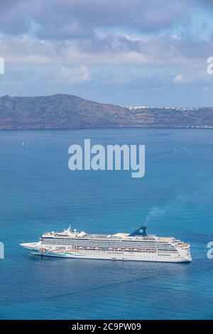 10.05.19. - Santorini, Grecia: Norwegian Jade nave da crociera nella baia di Santorini mare, acqua blu con scogliere vulcaniche sopra l'orizzonte. Cruiser di lusso Fira Foto Stock
