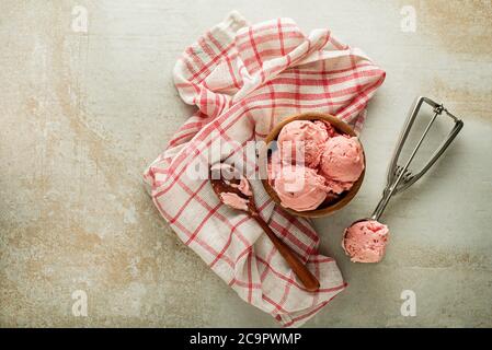 Fresco di gelato morbido o yogurt surgelato con sapori di frutti di bosco. Cucchiaio di gelato alla frutta, con un utenil Foto Stock