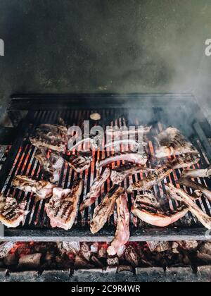 Costolette di agnello alla griglia. Grande griglia metallica con calici calde. Foto Stock