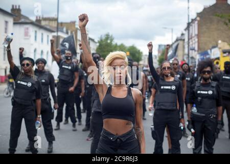 Imarn Ayton guida un esercito di manifestanti per unirsi alla celebrazione del giorno dell'emancipazione di Afrikan in Windrush Square, Brixton. Poiché le strade sono state temporaneamente bloccate fa parte del 'Lockdown Brixton'. Foto Stock