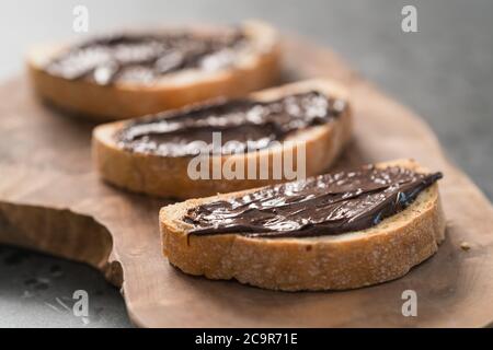 Ciabatta rustica con crema di cioccolato biologica su tavola di ulivo Foto Stock