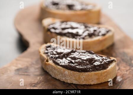 Ciabatta rustica con crema di cioccolato biologica su tavola di ulivo Foto Stock