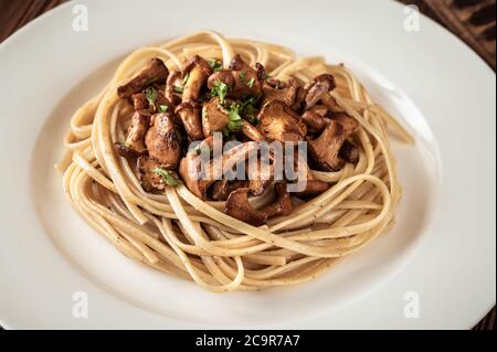 Porzione di pasta linguina con finferli fritti Foto Stock