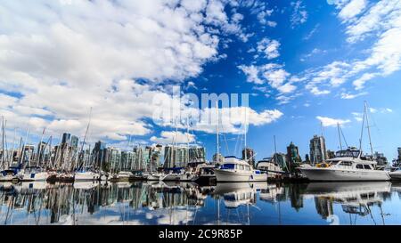 Barche parcheggiate nel porto di Vancouver con la città sullo sfondo Foto Stock