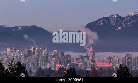 Skyline di Vancouver di notte - Vista aerea dal Queens Elizabeth Park in inverno con montagne innevate sullo sfondo Foto Stock