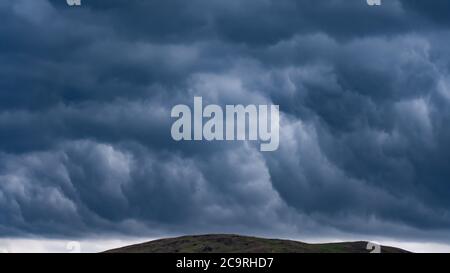 Temporale su una collina in una calda giornata estiva. Forti nuvole di pioggia blu al piombo in basso sopra il suolo Foto Stock