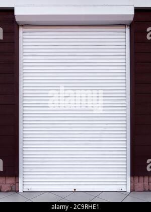 Rollet di colore bianco metallo, gli edifici chiusi una dverina una facciata un ingresso alla casa decorato in legno materiale. Foto Stock