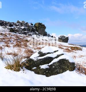 Paesaggio panoramico invernale rurale (affioramento roccioso, collina innevata, valle, cielo blu profondo) - Cow & Calf Rocks, Ilkley Moor, Yorkshire, Inghilterra, Regno Unito. Foto Stock