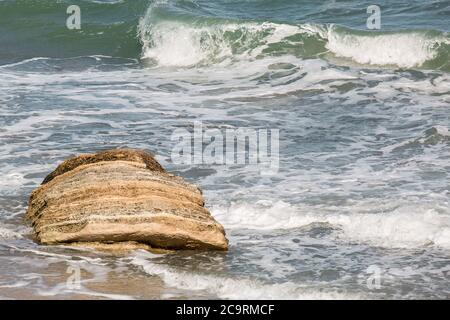 Tempesta schiumosa acqua marea mare onde lavare su costa con pietra. Foto Stock
