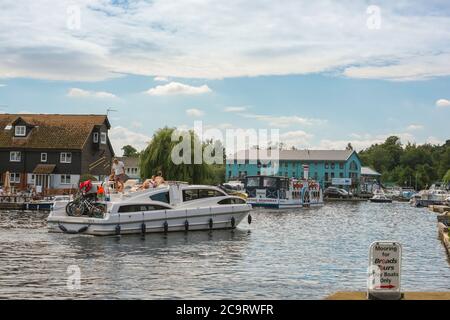 Wroxham Norfolk Broads, vista di una barca da diporto che naviga sul fiume Bure nel centro di Wroxham, nel cuore dei Norfolk Broads, Inghilterra, Regno Unito Foto Stock