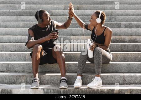 Una coppia nera sportiva che offre cinque colori dopo l'allenamento all'aperto Foto Stock