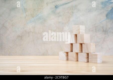 Cubetti giocattolo di legno su tavolo di legno e sfondo grigio Foto Stock