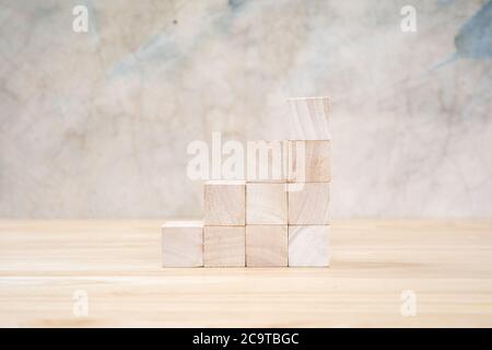Cubetti giocattolo di legno su tavolo di legno e sfondo grigio Foto Stock
