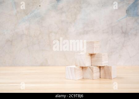 Cubetti giocattolo di legno su tavolo di legno e sfondo grigio Foto Stock