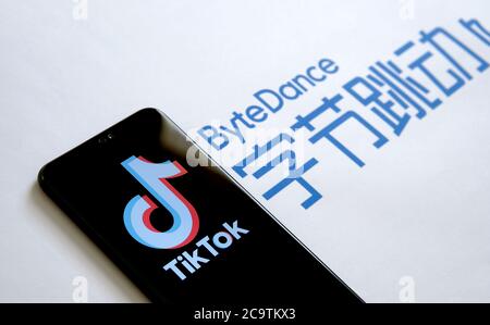 Stone / UK - Luglio 28 2019: Logo dell'app TikTok sullo schermo e logo della società ByteDance sul backgrond sfocato. Messa a fuoco selettiva. Foto Stock