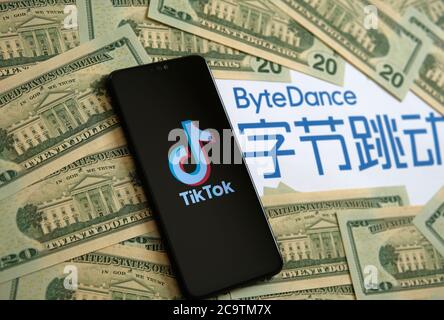 Stone / UK - 2 agosto 2020: TikTok app logo sul telefono, Casa Bianca visto su 20 dollari note e ByteDance società logo sullo sfondo sfocato. Se Foto Stock