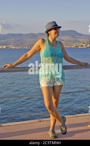 bella giovane donna in un cappello blu sulla spiaggia Foto Stock