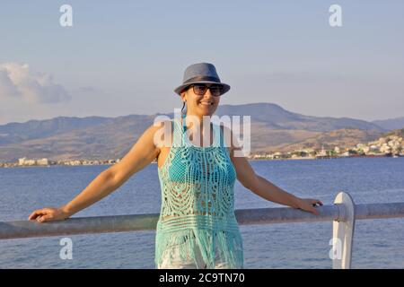 bella giovane donna in un cappello blu sulla spiaggia Foto Stock