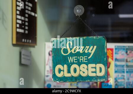 Un cartello appeso in una vetrina che dice scusa siamo chiusi Foto Stock