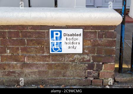 Un cartello all'esterno di una casa che indica che solo i titolari di badge disabili possono parcheggiare lì Foto Stock