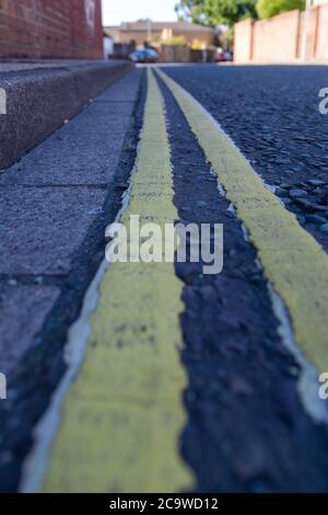 Un primo piano di doppie linee gialle su un inglese strada Foto Stock