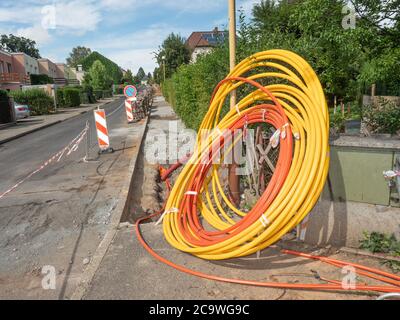 Bobine di involucri in plastica, cavo dati inserito in trincea sotterranea. Cavo in fibra ottica per Internet veloce. Area case residenti. Foto Stock