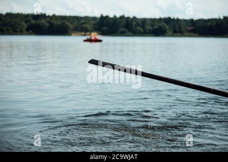 gli atleti in vacanza sono impegnati nel canottaggio, nuotatori su remi di legno colpire l'acqua, spruzzando un sacco di gocce intorno Foto Stock