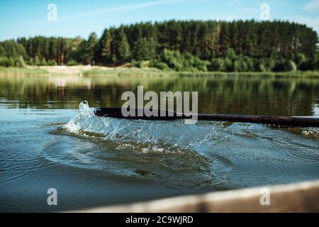 gli atleti in vacanza sono impegnati nel canottaggio, nuotatori su remi di legno colpire l'acqua, spruzzando un sacco di gocce intorno Foto Stock