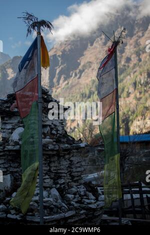 Colorate bandiere buddiste di preghiera appese, soffiano nel vento dalle montagne sul circuito di Annapurna, Nepal Foto Stock