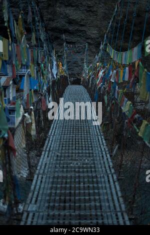 Chame sospensione ponte colorato buddista preghiera bandiere sul fiume Marshyangdi, circuito Annapurna, Nepal Foto Stock