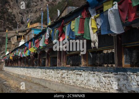 Ruote buddiste di preghiera e bandiere, Pisang superiore, trekking circuito Annapurna, Himalaya, Nepal Foto Stock