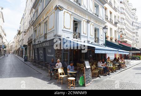 La gente seduta in un tradizionale francese cafe au rocher de Cancale su Rue Montorgueil street a Parigi, Francia. Foto Stock