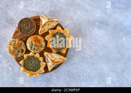 Pasticceria, fatayer o samosa, manaqeesh con zaatar e formaggio bianco su tavola di legno Foto Stock